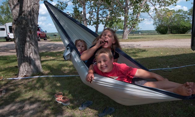 These three cousins are enjoying grandma’s homemade cookies in a hammock.