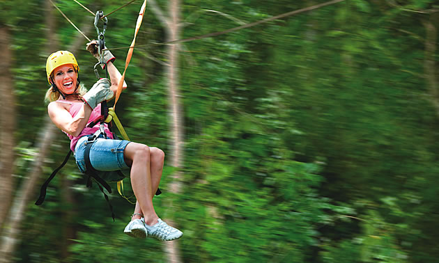 lady sliding down a zipline like the one that will be added in Fernie BC