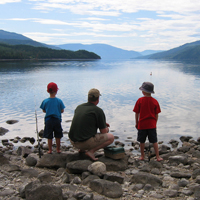 kids learning to fish on a lake