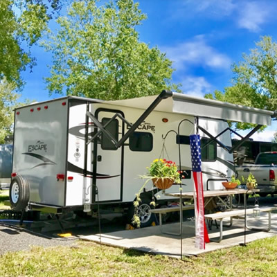 Fifth wheel camper parked at campsite. 