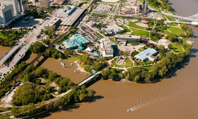 aerial view of the edge of a river and heritage park along the shore