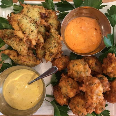 Plate of fritters and dishes of sauce. 
