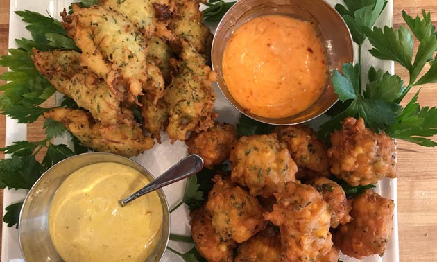 Plate of fritters and dishes of sauce. 
