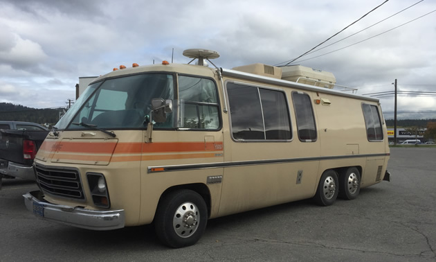 Picture of vintage GMC motorhome, silver and blue. 