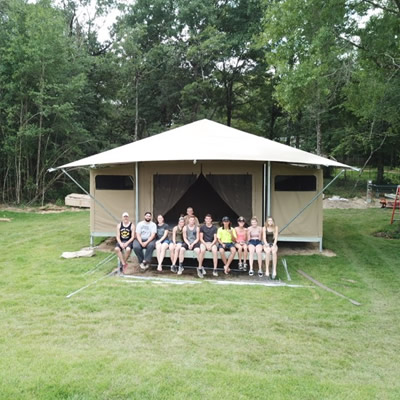 The O'Neill's Millennial tent building crew sit on the front porch of one of their seven recently installed Eco Tents, which feature electricity and running water.