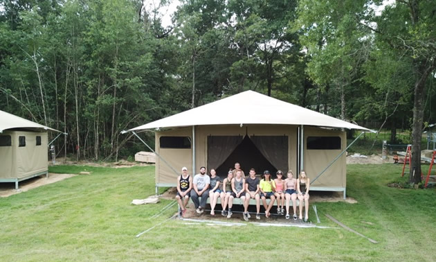 The O'Neill's Millennial tent building crew sit on the front porch of one of their seven recently installed Eco Tents, which feature electricity and running water.