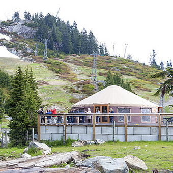 Tourists standing on the porch of the yurt lookout at Grouse Mountain