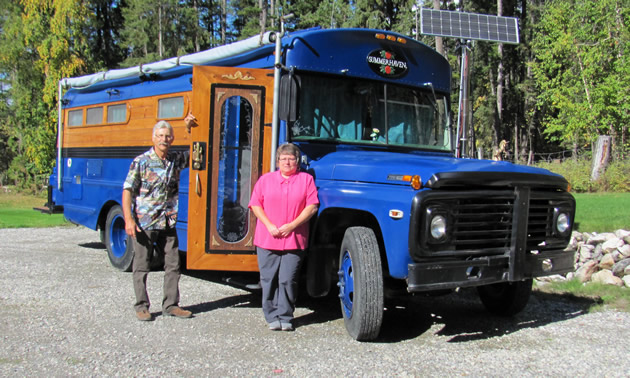 Bob and Carol Braisher stand outside of their converted school bus, fondly named Gus the Bus.