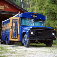 Bob and Carol Braisher stand outside of their converted school bus, fondly named Gus the Bus.