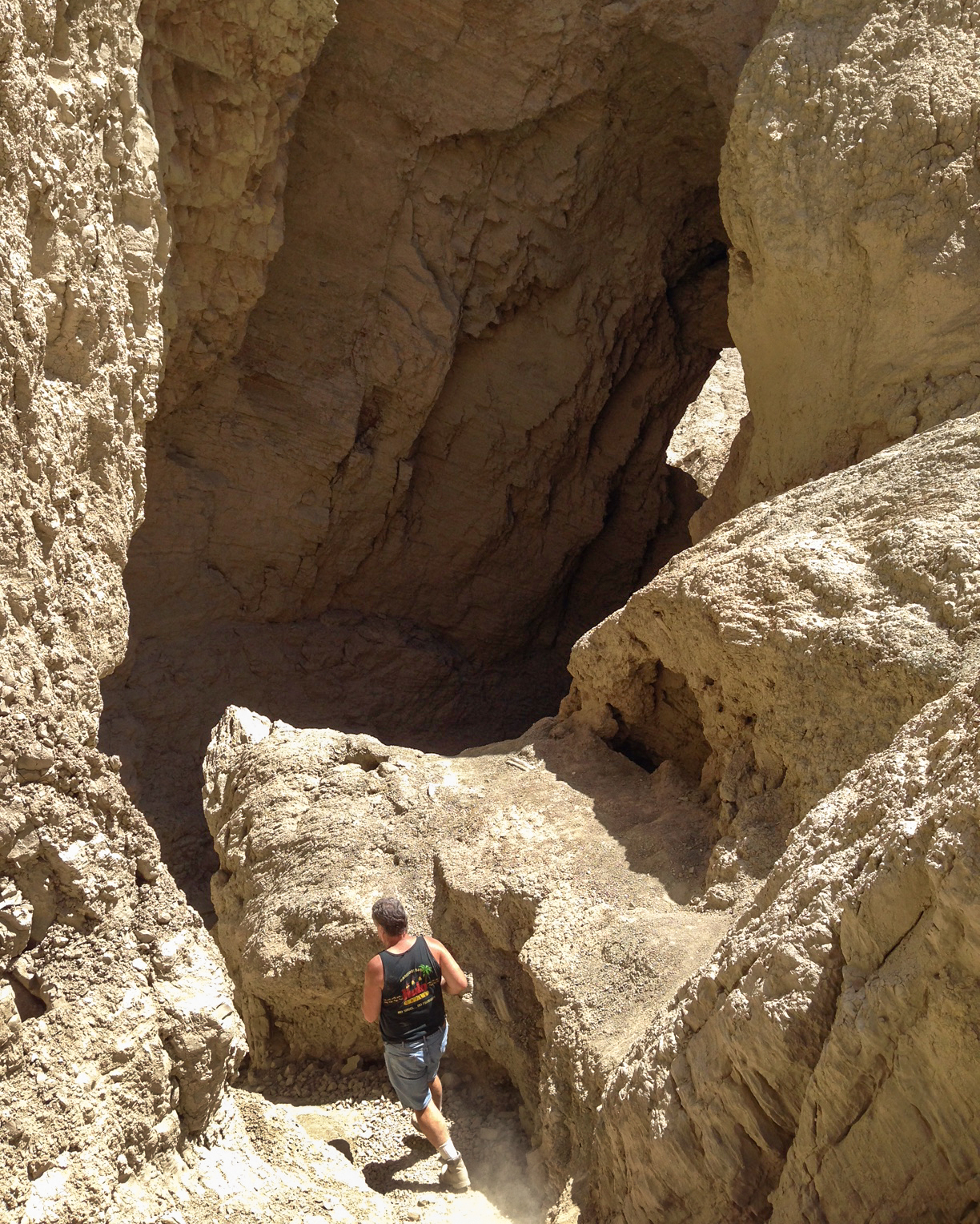Don Kelley is walking into the entrance of one of the 22 known mud caves in the state park.