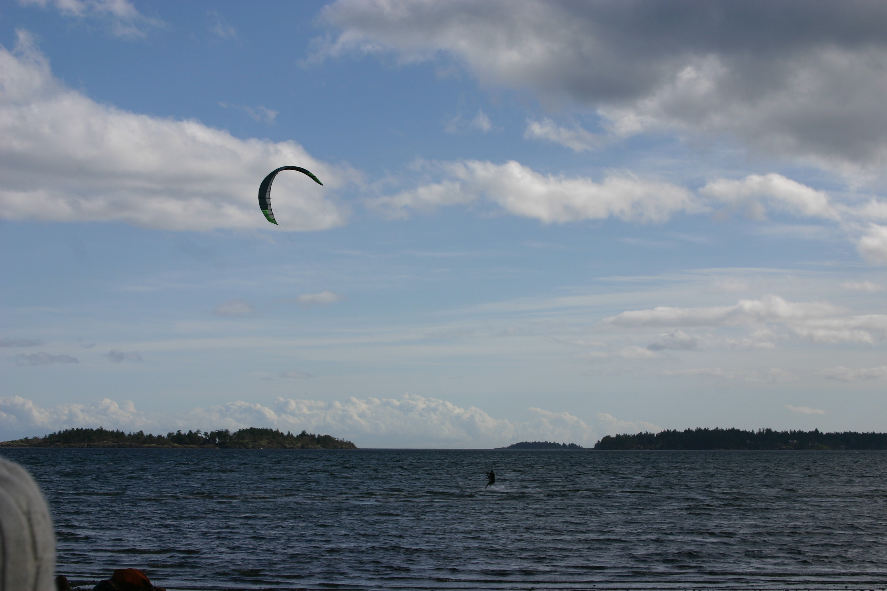 A para-sail skipping over the ice water at Rathrevor Beach. 