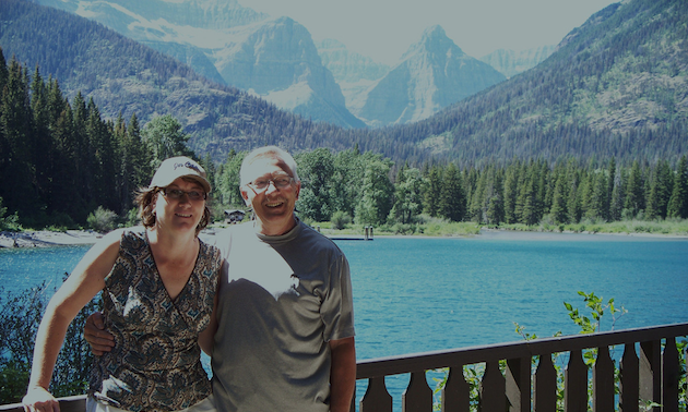 couple standing by an alpine lake