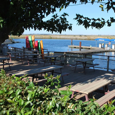 View of picnic benches and lake in background. 
