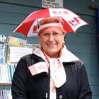 Two German tourists wearing umbrella hats with Canadian flag print