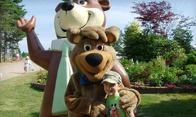 Child posing with a Yogi Bear mascot. 