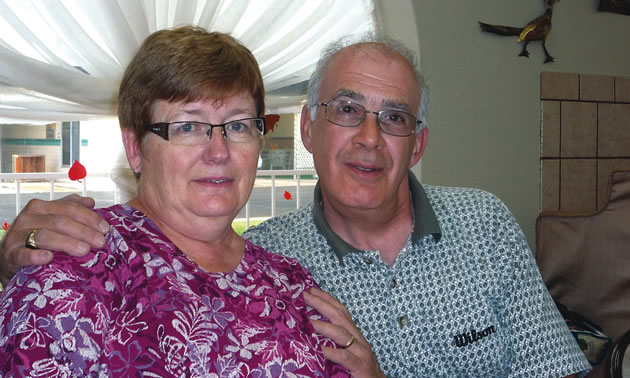 Photo of an older couple sitting on the couch together. 