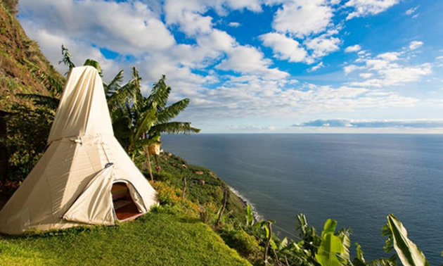 Tent set up on ocean shoreline.