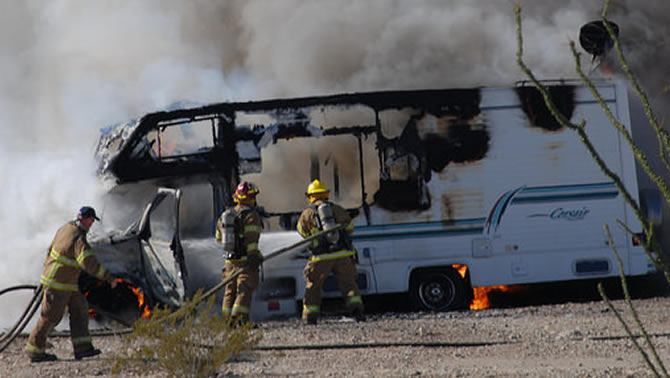 Picture of three firemen putting out RV fire 