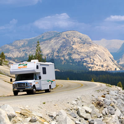 Picture of camper travelling on highway with mountain scene in background. 