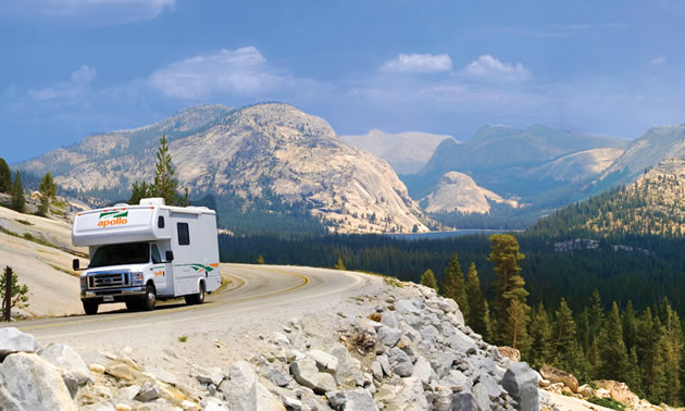 Picture of camper travelling on highway with mountain scene in background. 