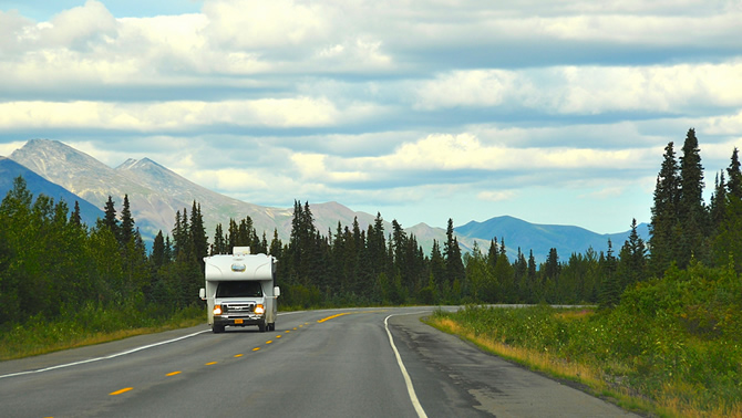 A picture of an RV travelling down a road.