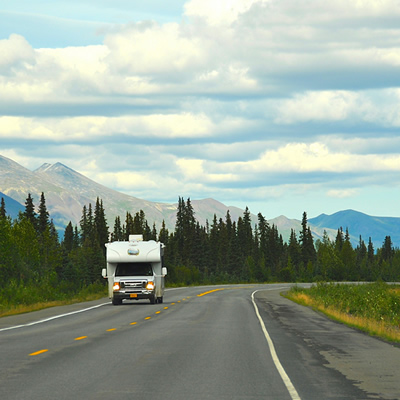 A picture of an RV travelling down a road. 