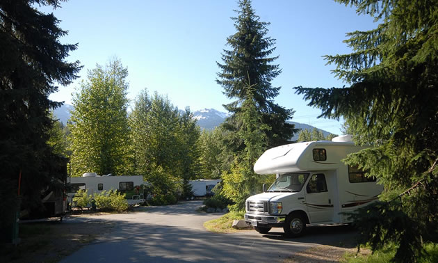 This is a view of the RV camping sites with a camper parked in one site. 