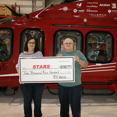 Duane and Lynda Pilson proudly present STARS with a cheque for $2,400 gathered at the 11th Annual RV West Rally held in Stettler.