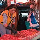 a woman arranges some fresh prawns in her market display