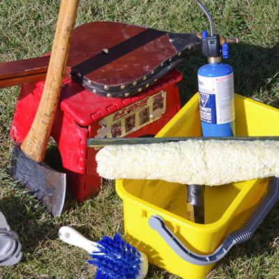 Shown are some of the author's essential items packed in his RV: a bucket, brush, bellows, an axe and a propane cylinder.