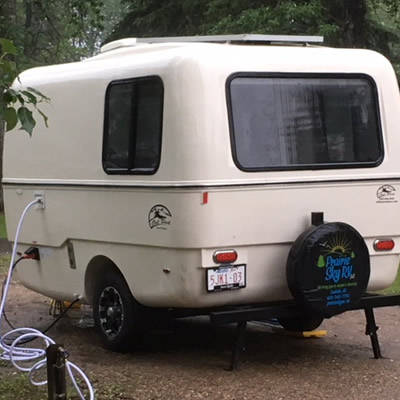 White vintage-looking Boler-style trailer. 