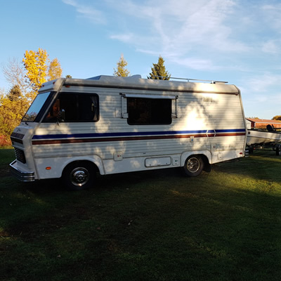 A 1982 Triple E motorhome, parked in a field. 