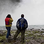 man and woman standing beside a waterfall