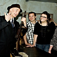 Actors in period costume take a group of guests through the Moose Jaw Tunnels, telling them a story of gangsters an prohibition.