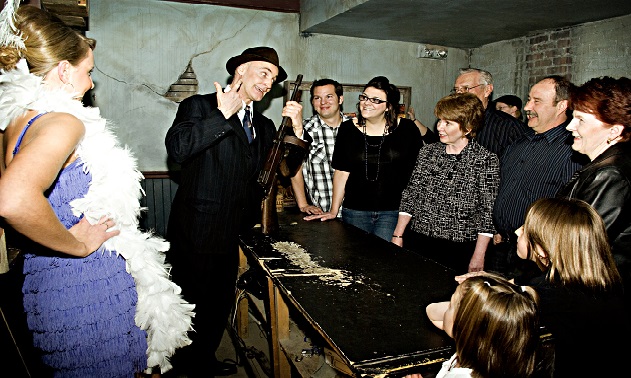 Actors in period costume take a group of guests through the Moose Jaw Tunnels, telling them a story of gangsters an prohibition.