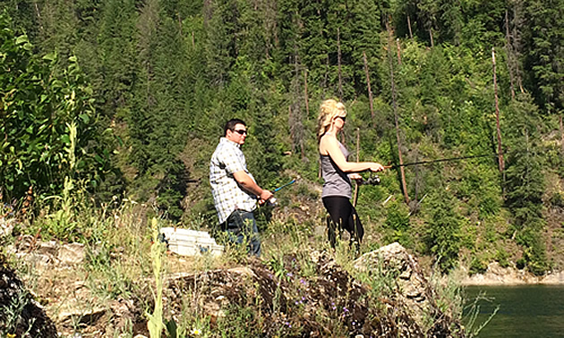 Will Buckley and Nicole Lind standing on a rock and fishing the Pend d'Oreille River in British Columbia