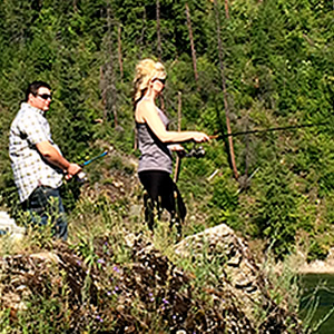 Will Buckley and Nicole Lind standing on a rock and fishing the Pend d'Oreille River in British Columbia