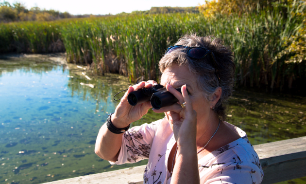 A lady looking through binoculars.