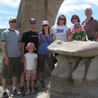 people standing next to limestone hoodoo formations on a summer day wearing casual attire