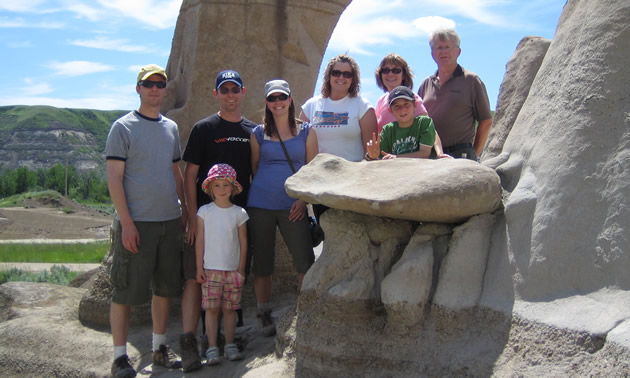 people standing next to limestone hoodoo formations on a summer day wearing casual attire