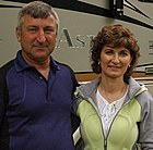 Middle-aged couple stand beside their motorhome.