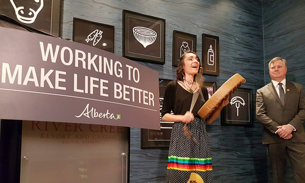 Minister Feehan watches Mackenzie Brown from Warrior Women perform a traditional song in her Cree language.