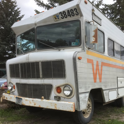 Winnebago motorhome with orange and yellow 'Flying W' logo on side. 