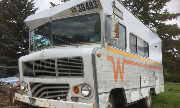 Winnebago motorhome with orange and yellow 'Flying W' logo on side. 