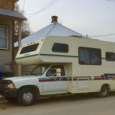 A Winnebago Warrior motorhome parked on city street. 