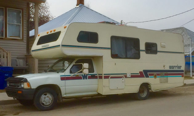 A Winnebago Warrior motorhome parked on city street. 