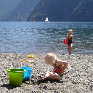 Two little blond girls playing on a beach