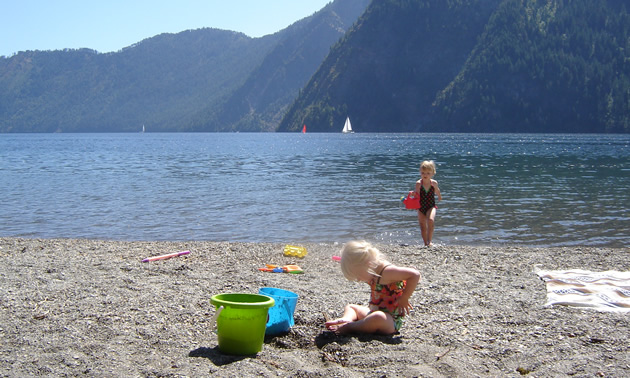 Two little blond girls playing on a beach