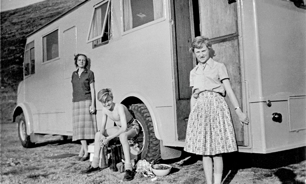 A black and white photo shows three children, including Stefan Sykut, in front of a wooden caravan.