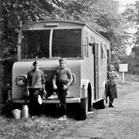 A black and white photo shows three children, including Stefan Sykut, in front of a wooden caravan.